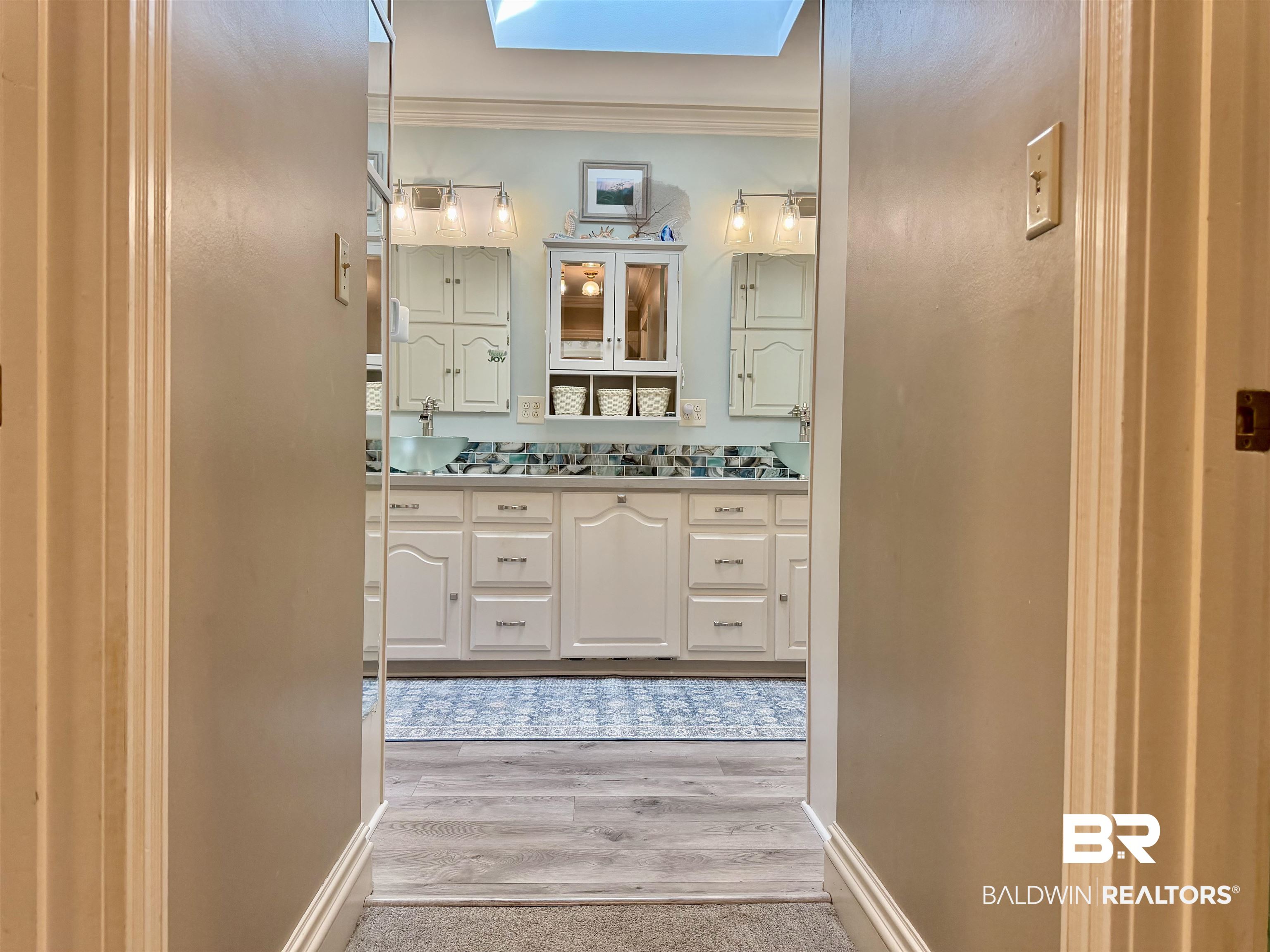 2944 Appleton Road Brewton, AL 36426 - Photo 17 of 65 Bathroom with vanity, crown molding, a skylight, and light wood-type flooring