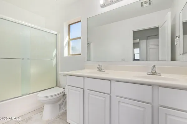 a bathroom with a toilet a sink a mirror a shower and vanity