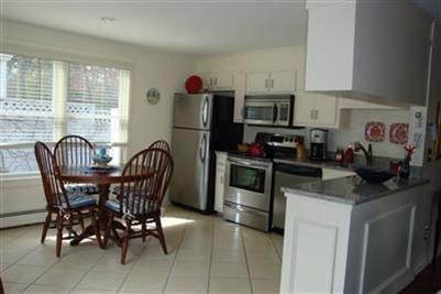 11 Summersea Road Mashpee, MA 02649 - Photo 4 of 12 a kitchen with stainless steel appliances granite countertop a stove a refrigerator a sink a dining table and chairs
