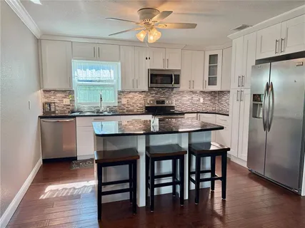 a kitchen with granite countertop white cabinets stainless steel appliances and a sink