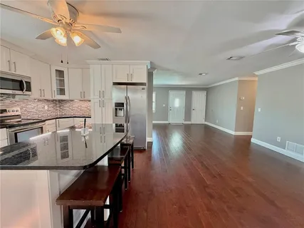 a bathroom with a granite countertop toilet a sink and a mirror