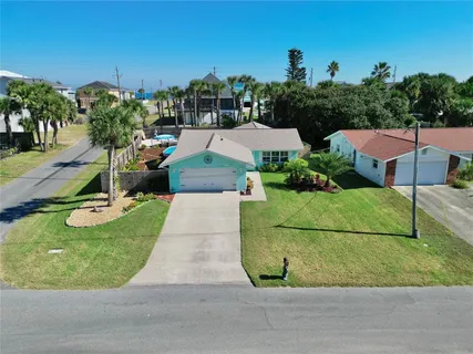 an aerial view of a house with a garden and lake view