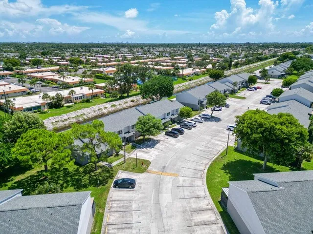 an aerial view of a city with lots of residential buildings ocean and mountain view in back