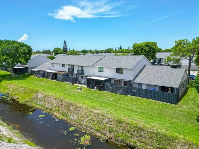 an aerial view of a house with swimming pool garden and mountain view in back