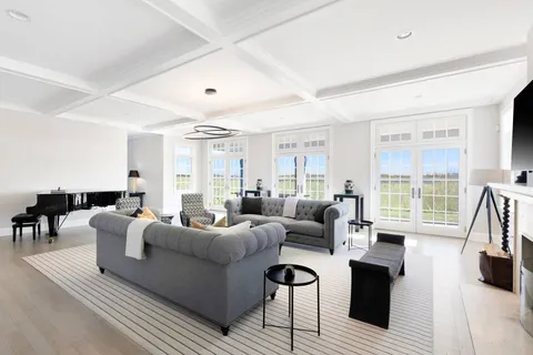 a living room with furniture a large window and a wooden floor