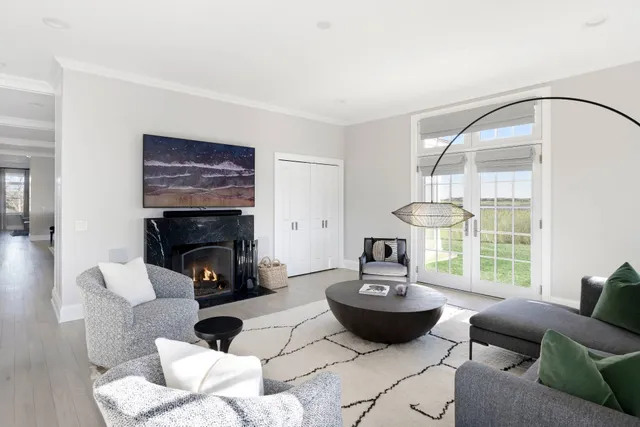 a living room with furniture a fireplace and a large window