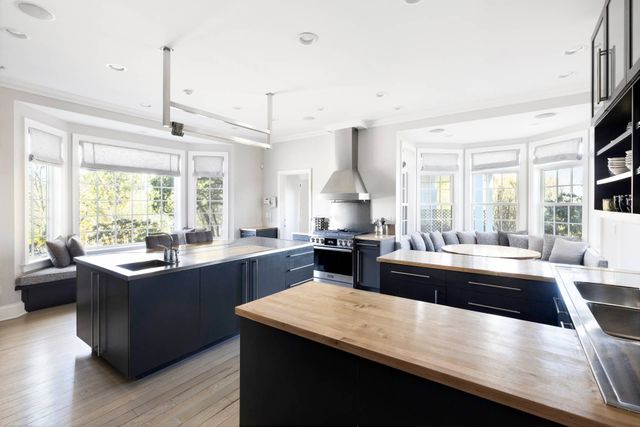 a kitchen with kitchen island granite countertop a sink appliances and cabinets