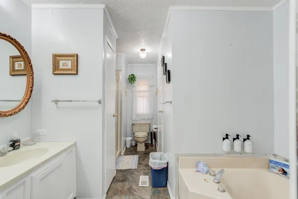 a bathroom with a granite countertop toilet a sink and a mirror