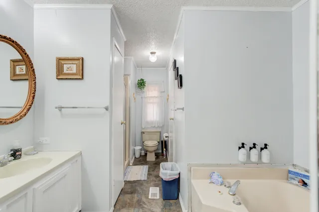 a bathroom with a granite countertop toilet a sink and a mirror