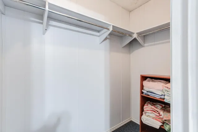 a view of walk in closet with empty racks