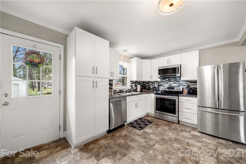 2508 Milton Road Charlotte, NC 28215 - Photo 5 of 17 a kitchen with white cabinets and stainless steel appliances