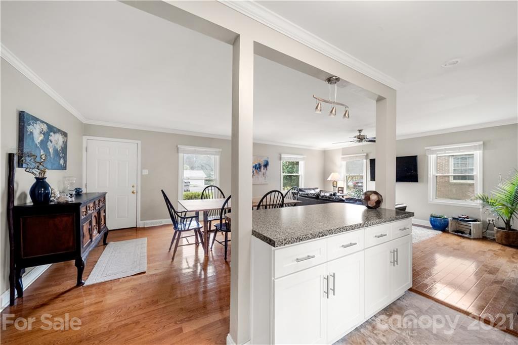 2508 Milton Road Charlotte, NC 28215 - Photo 8 of 17 a kitchen with stainless steel appliances granite countertop a stove a sink a oven a dining table and chairs with wooden floor