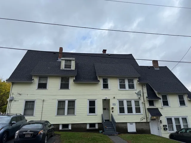 a aerial view of a brick building next to a yard