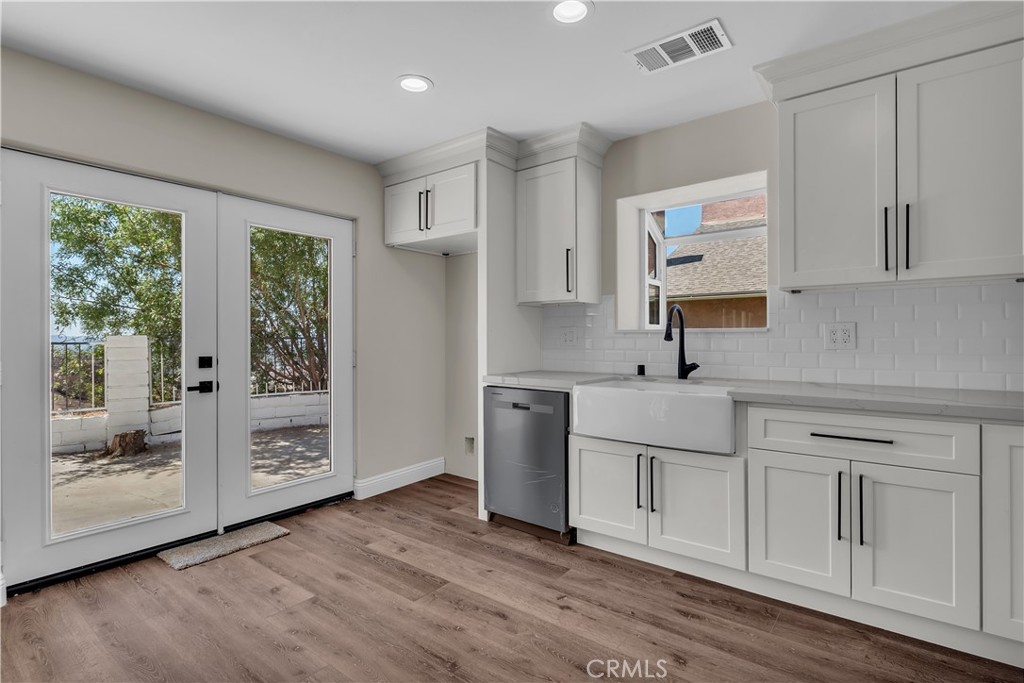12524 Chanute Street Pacoima, CA 91331 - Photo 15 of 47 a kitchen with white cabinets and wooden floors