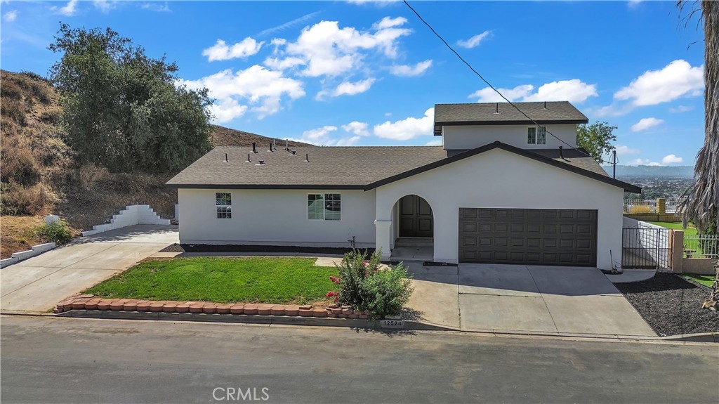 12524 Chanute Street Pacoima, CA 91331 - Photo 2 of 47 a front view of a house with a yard and garage