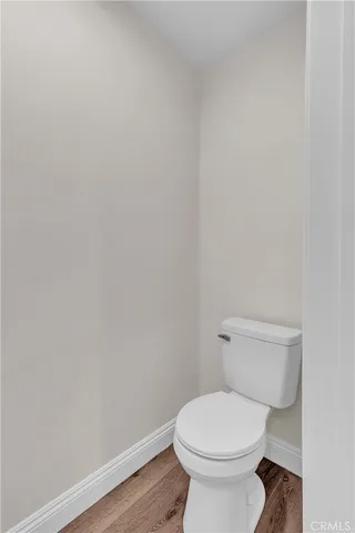 a white toilet sitting next to a white wall