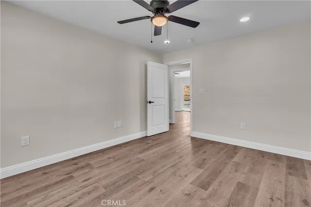 wooden floor in an empty room with a ceiling fan