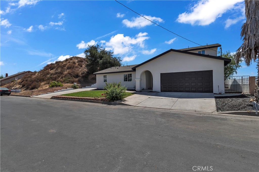 12524 Chanute Street Pacoima, CA 91331 - Photo 5 of 47 a front view of a house with a yard and garage