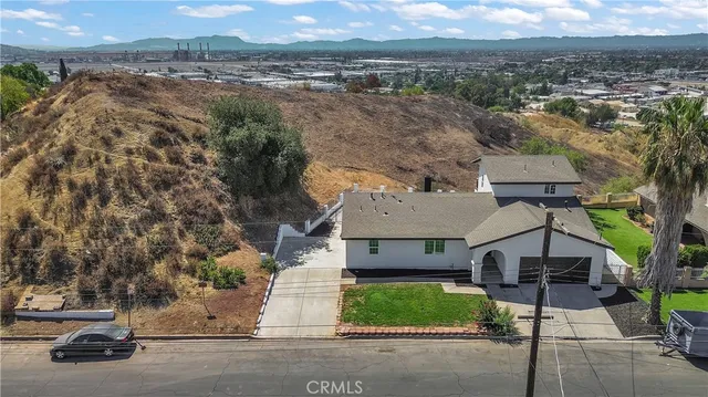 an aerial view of a house with a yard and large tree