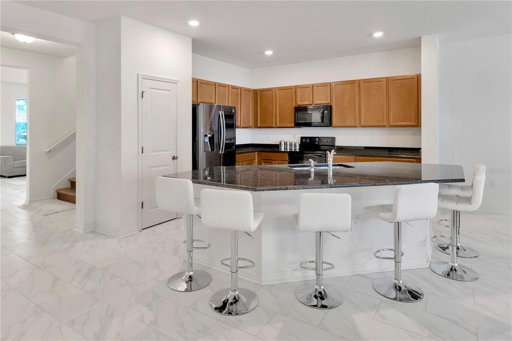 11530 Brighton Knoll Loop Riverview, FL 33579 - Photo 11 of 64 a kitchen with stainless steel appliances kitchen island granite countertop a sink and cabinets