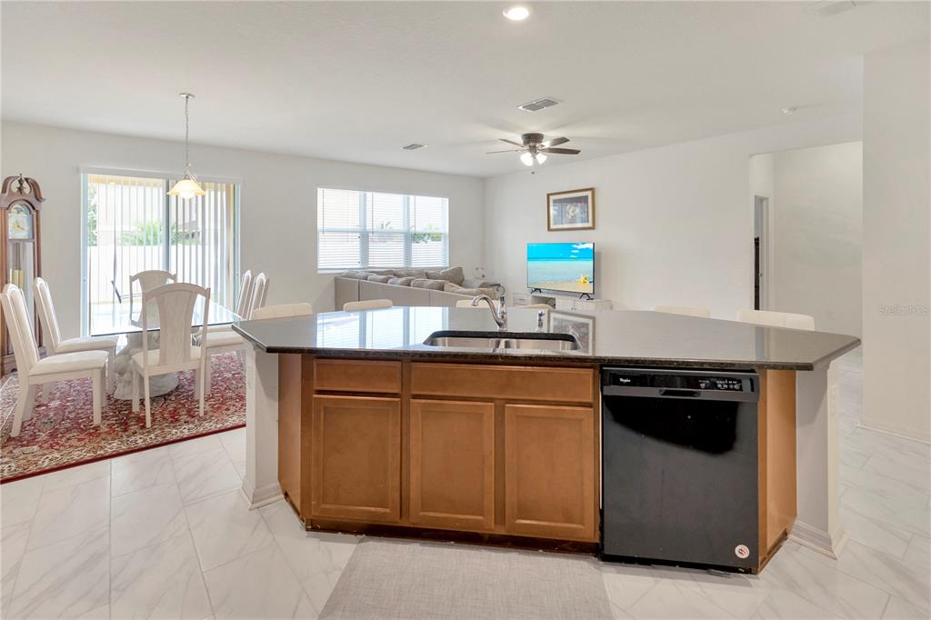 11530 Brighton Knoll Loop Riverview, FL 33579 - Photo 13 of 64 a kitchen with granite countertop a sink stainless steel appliances and cabinets