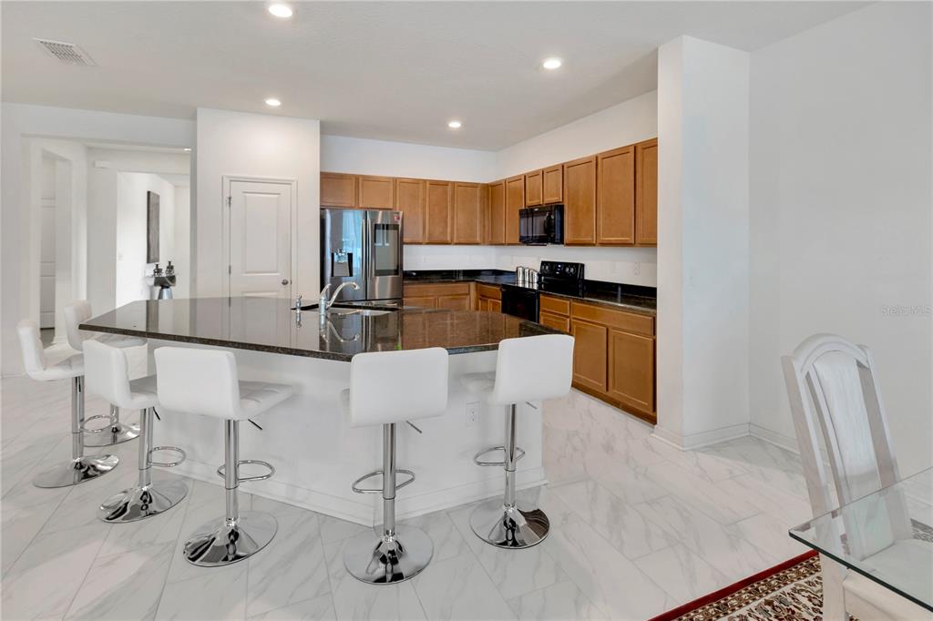 11530 Brighton Knoll Loop Riverview, FL 33579 - Photo 4 of 64 a kitchen with stainless steel appliances kitchen island granite countertop a sink and cabinets