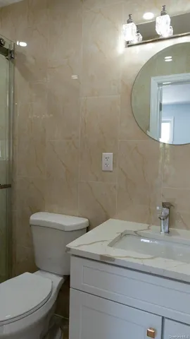 a bathroom with a granite countertop toilet sink and mirror