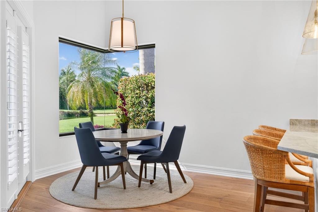 3296 Lookout Lane Naples, FL 34112 - Photo 12 of 39 a view of a dining room with furniture and wooden floor