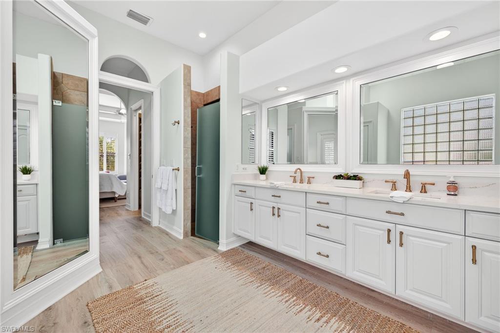 3296 Lookout Lane Naples, FL 34112 - Photo 16 of 39 a spacious bathroom with a double vanity sink a large mirror and a shower