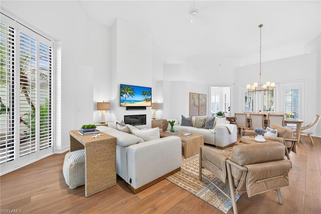 3296 Lookout Lane Naples, FL 34112 - Photo 3 of 39 a living room with furniture wooden floor and a chandelier