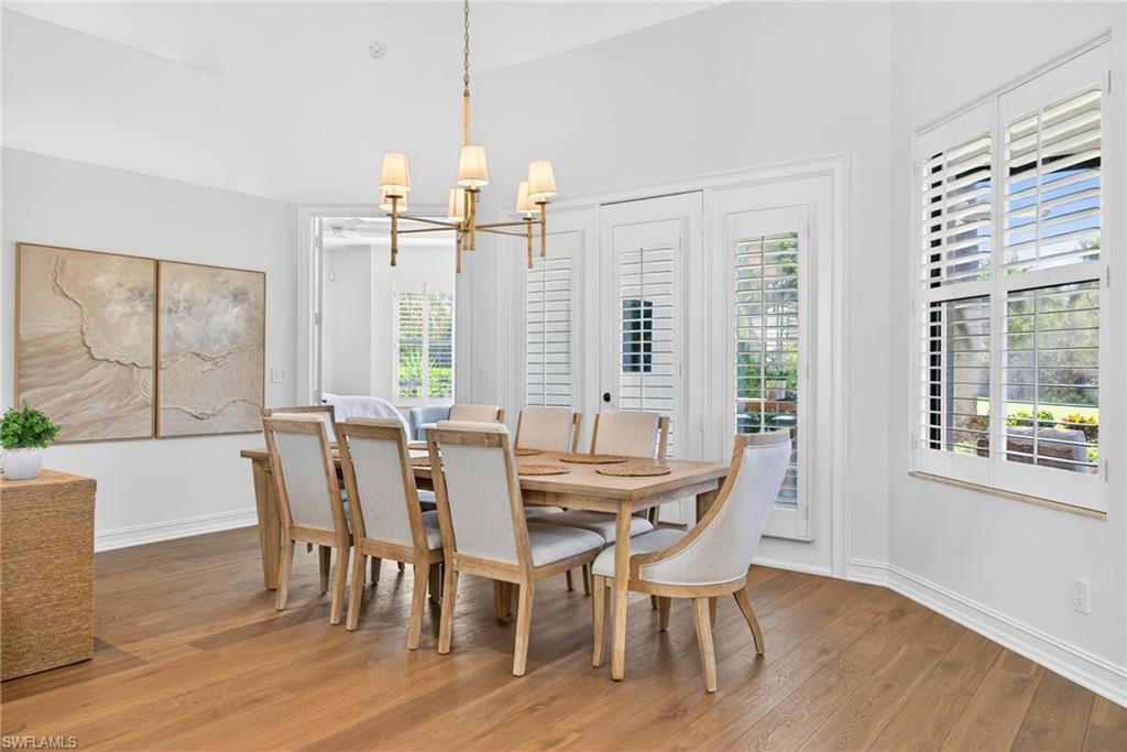 3296 Lookout Lane Naples, FL 34112 - Photo 7 of 39 a view of a dining room with furniture large windows and wooden floor