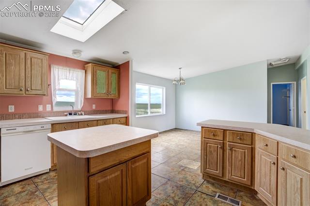 1435 Equestrian Point Yoder, CO 80864 - Photo 16 of 49 Kitchen featuring dishwasher, light countertops, plenty of natural light, and a skylight
