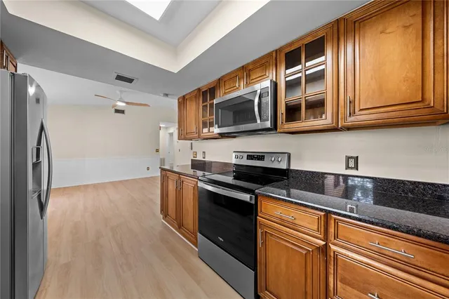 a spacious bathroom with a granite countertop sink mirror and a toilet