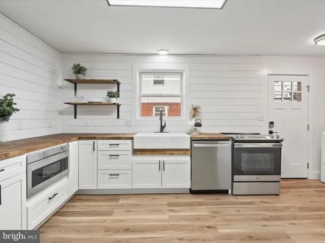a kitchen with stainless steel appliances white cabinets and a sink