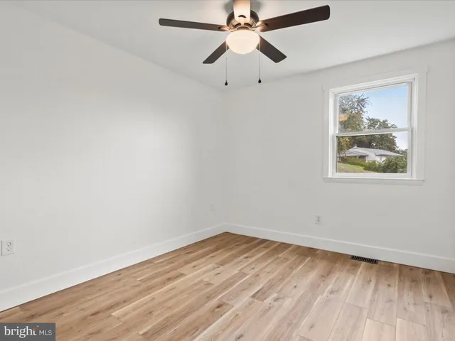 an empty room with a window and wooden floor