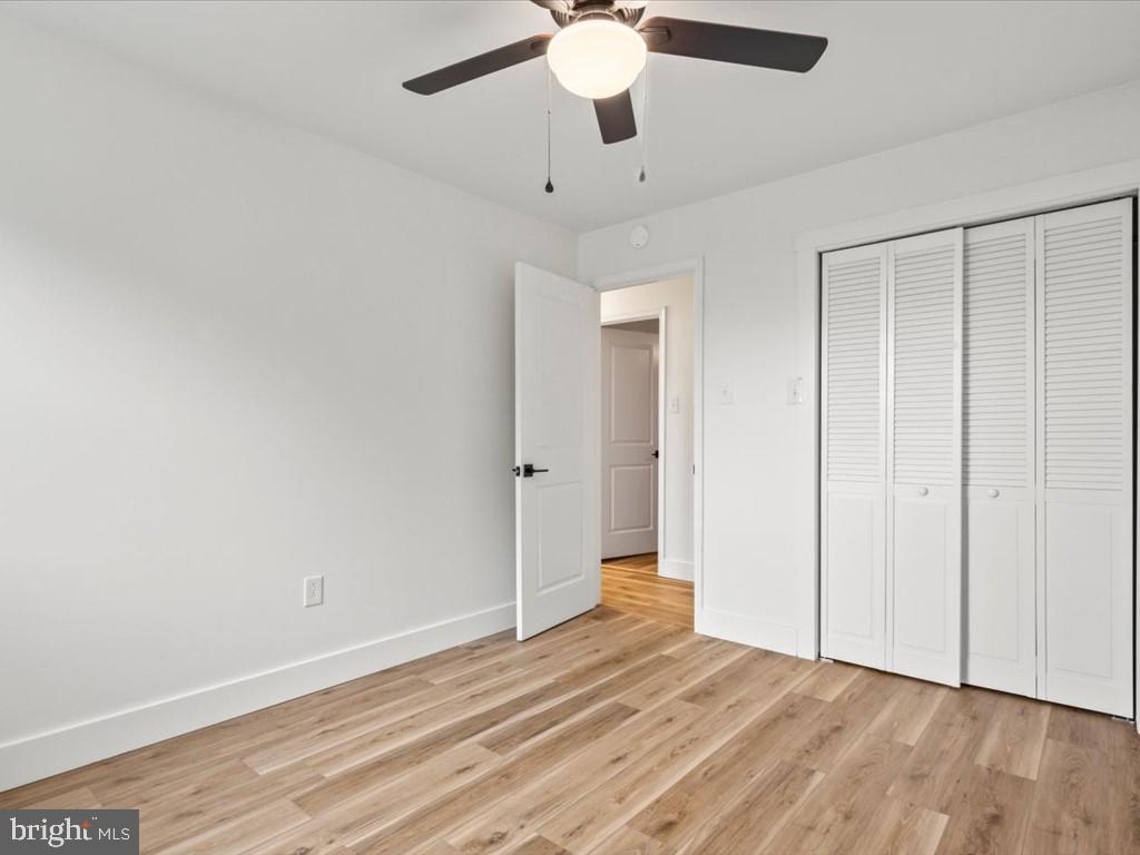 1310 Delaware Lane, Unit A Hagerstown, MD 21740 - Photo 18 of 24 an empty room with wooden floor fan and windows