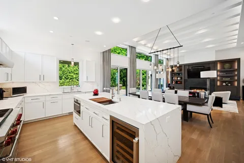 a kitchen with a stove a sink a microwave a dining table and chairs