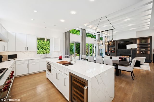 a kitchen with a stove a sink a microwave a dining table and chairs