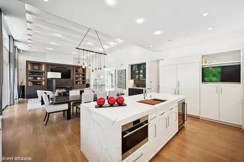 a kitchen that has a lot of white furniture and wooden floor
