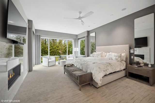 a spacious bedroom with a large bed and a flat tv screen on dresser