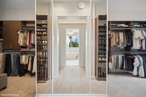a view of walk in closet with clothes and shoes