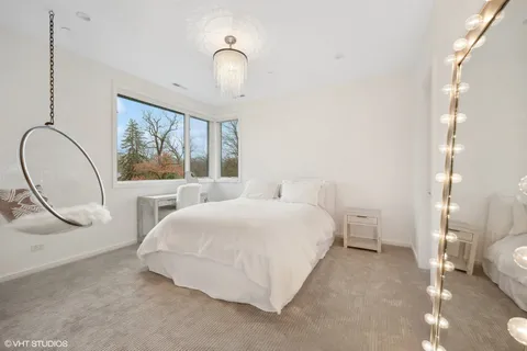 a bedroom with a bed and a large mirror on the dresser