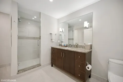a bathroom with a double vanity sink toilet and shower