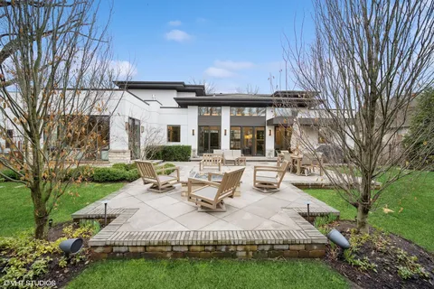 a view of a patio with couches table and chairs and potted plants and large tree