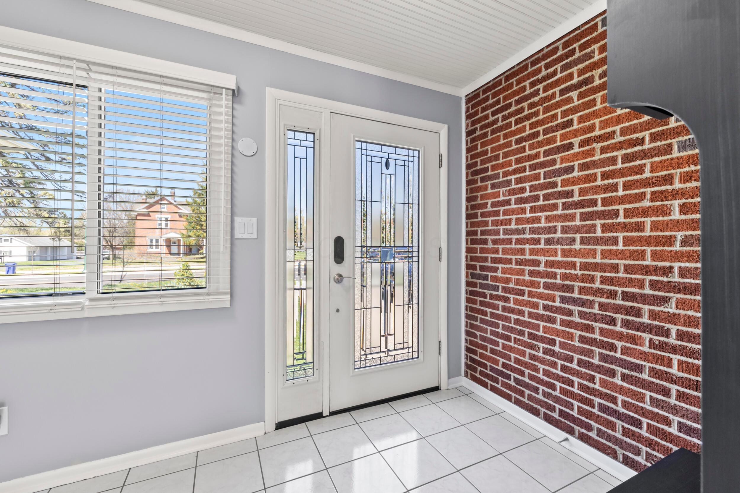 2209 Fishinger Road Columbus, OH 43221 - Photo 6 of 39 Large entry with new door, brick wall and great natural daylight