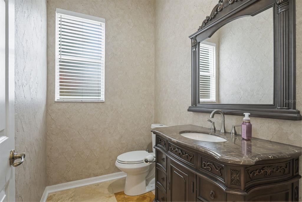 9103 Creedmoor Lane New Port Richey, FL 34654 - Photo 26 of 90 a bathroom with a granite countertop sink a toilet and a mirror