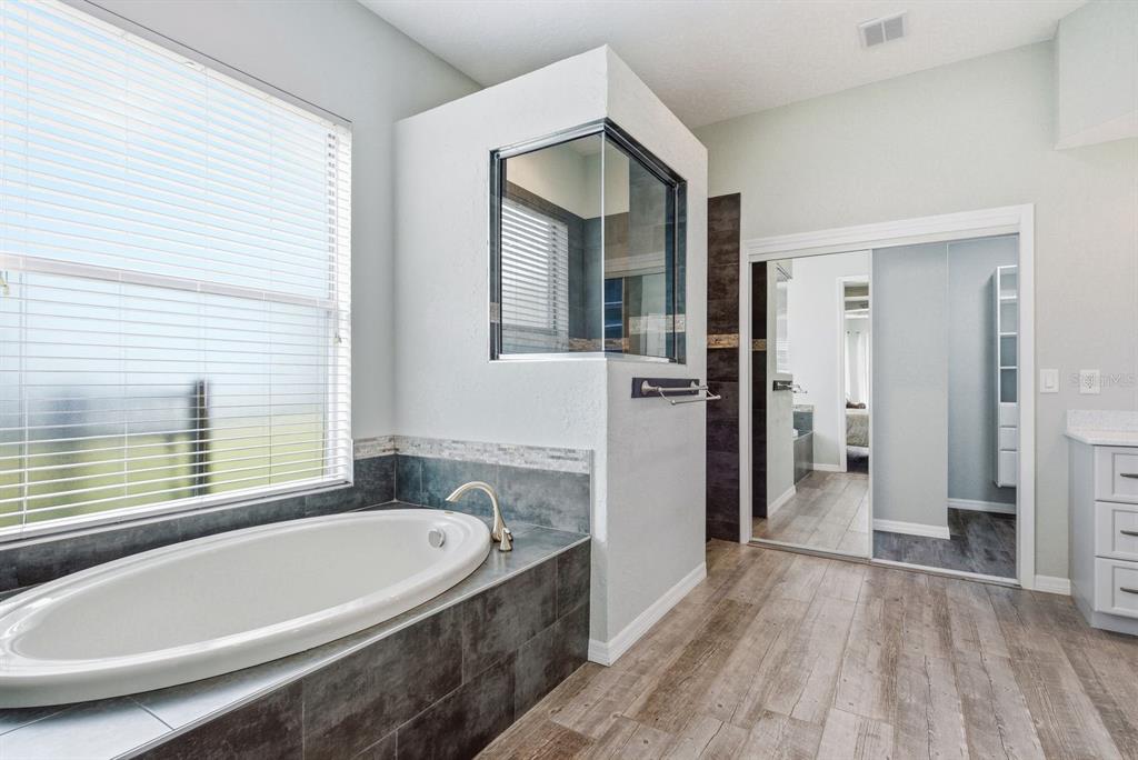 9103 Creedmoor Lane New Port Richey, FL 34654 - Photo 40 of 90 a bathroom with a bathtub and a shower