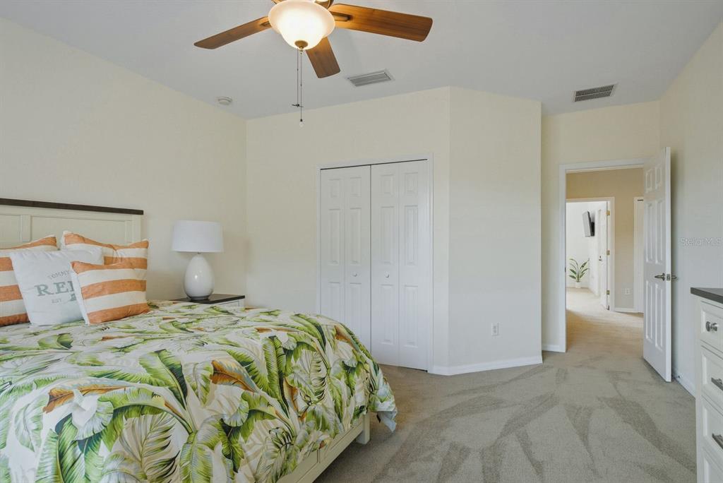 9103 Creedmoor Lane New Port Richey, FL 34654 - Photo 45 of 90 a bedroom with a bed and a chandelier