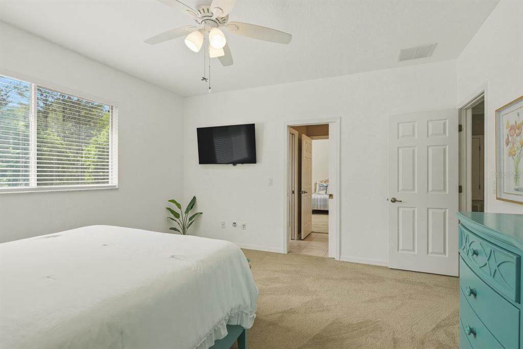 9103 Creedmoor Lane New Port Richey, FL 34654 - Photo 48 of 90 a bedroom with a bed and a flat tv screen on dresser