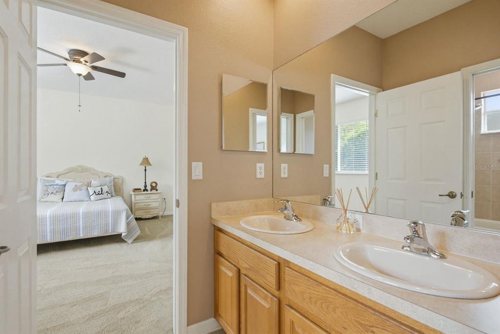9103 Creedmoor Lane New Port Richey, FL 34654 - Photo 49 of 90 a en suite bathroom with a double vanity sink and a mirror